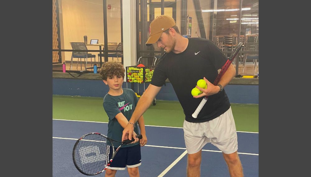 tennis instructor and child